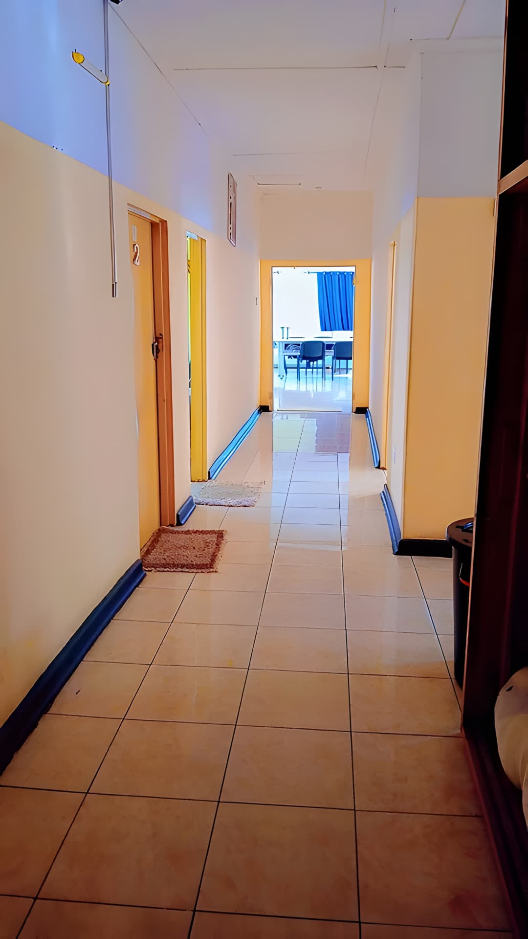 A tiled hallway leading past the Quantico Lodge rooms